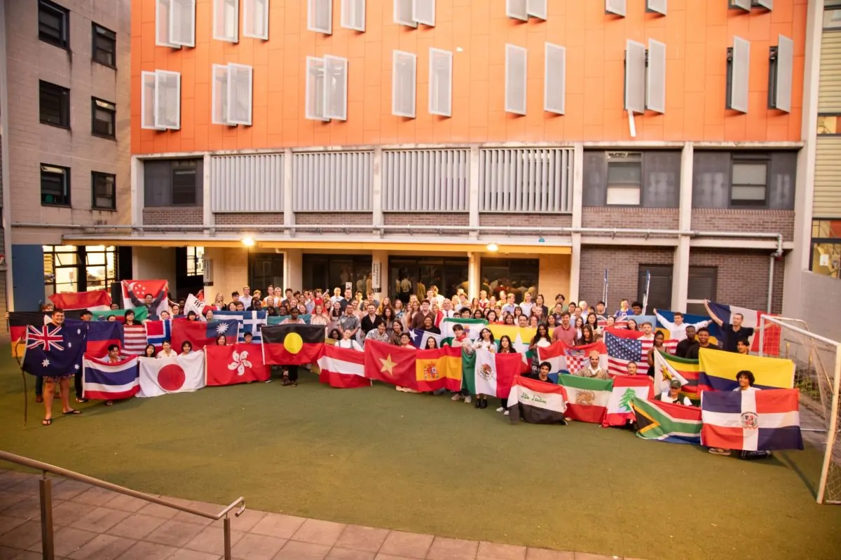 Robert Menzies College residents holding flags from their home countries at the annual International Night dinner