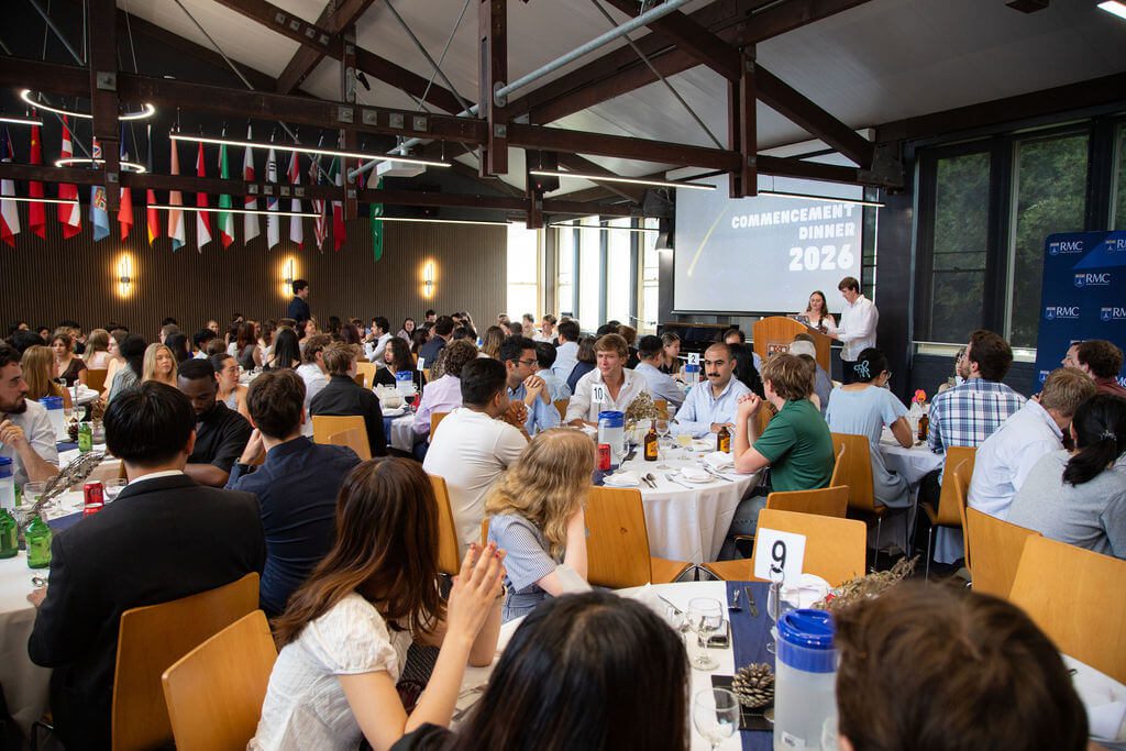 Residents seated at round tables at the Robert Menzies College Commencement Dinner 2026, with international flags overhead.